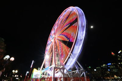 Low angle view of illuminated ferris wheel at night