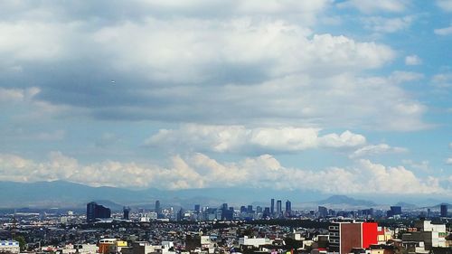 Cityscape against cloudy sky