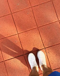 Low section of woman standing on footpath