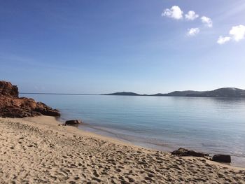 Scenic view of beach against clear blue sky