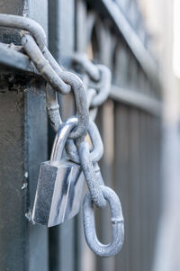 Close-up of chain tied up on metal fence