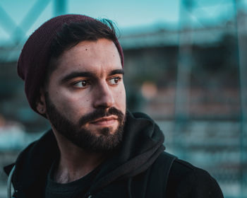 Close-up of thoughtful young man looking away in city