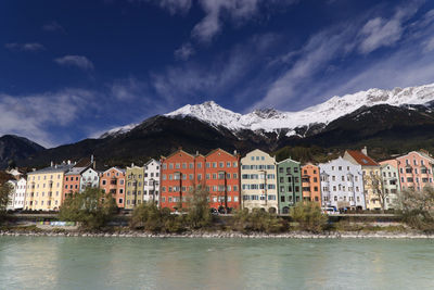 Buildings by river against sky