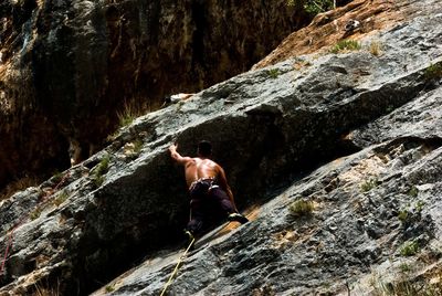 Low angle view of man climbing mountain