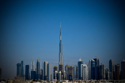 Modern buildings in city against blue sky