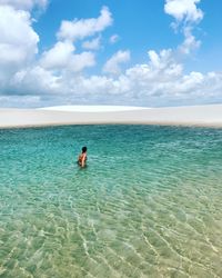 Young woman in sea against sky