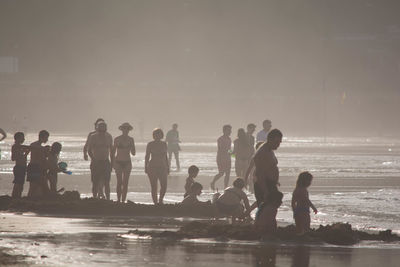 Group of people at beach during sunset