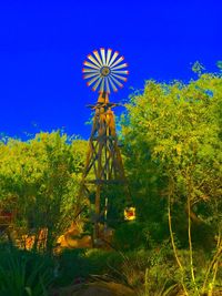 Low angle view of ferris wheel against clear blue sky