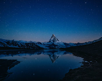 Scenic view of snowcapped mountains against sky at night