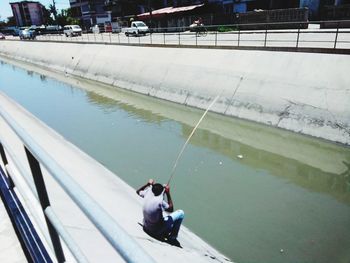 High angle view of people sitting on lake