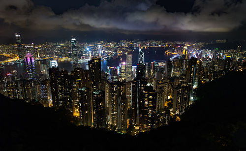 Illuminated cityscape against sky at night