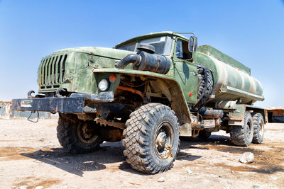 Abandoned truck on land against clear sky