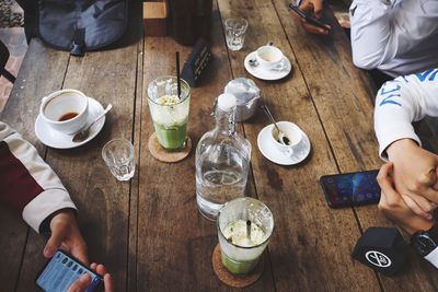 Friends having drinks while sitting at table in cafe