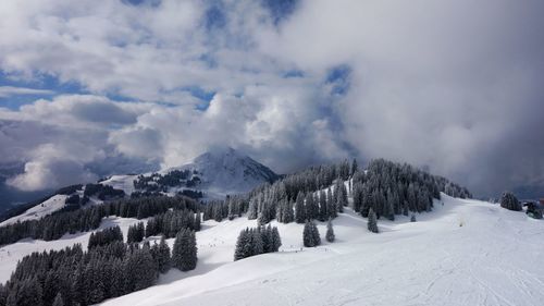 Panoramic view of snow covered mountains against sky