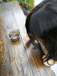 High angle view of woman staining wooden table