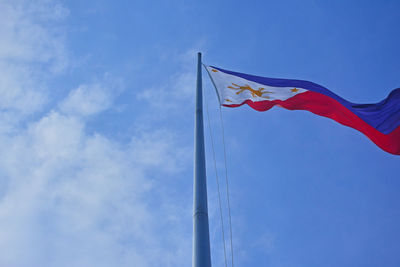 Low angle view of flag against blue sky