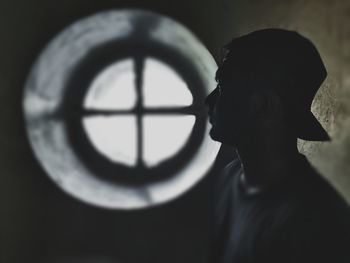 Portrait of silhouette boy standing against window
