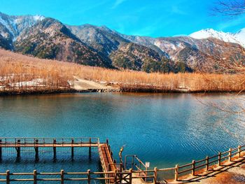 Scenic view of lake by mountains against sky