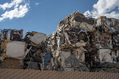 Low angle view of garbage on metal structure against sky