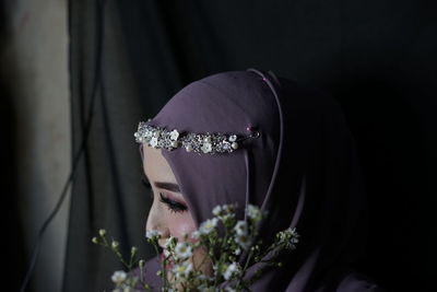 Close-up of woman holding flower bouquet against blurred background