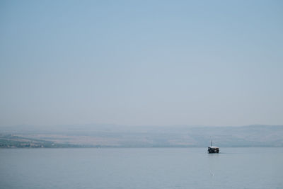 Sailboat sailing on sea against clear sky