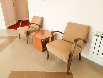 Empty chairs and table against wall at home