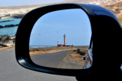 Reflection of lighthouse on side-view mirror