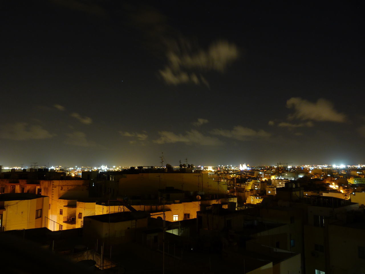 HIGH ANGLE VIEW OF ILLUMINATED CITYSCAPE AGAINST SKY