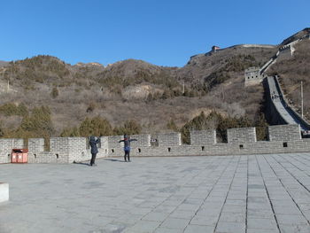 Woman photographing daughter at great wall of china