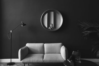 Electric lamp on table against illuminated wall at home