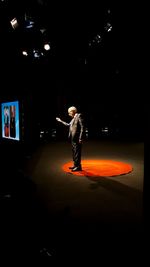 Full length of man standing in illuminated stage