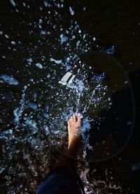 Low section of man walking in sea