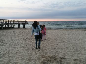 Scenic view of beach against sky at dusk