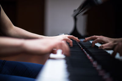 Cropped image of hands playing piano