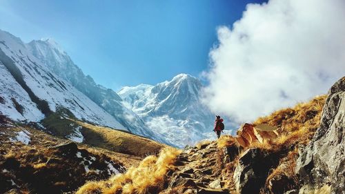 Person standing on mountain against sky
