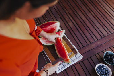 High angle view of hand holding ice cream on table