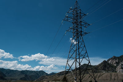 Low angle view of electricity pylon against sky