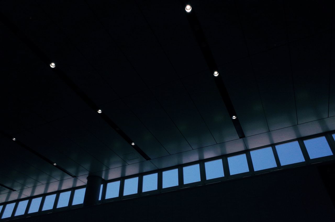 LOW ANGLE VIEW OF ILLUMINATED LIGHTS ON BUILDING WALL