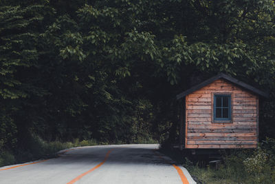 Wooden bungalow is in dark green forest