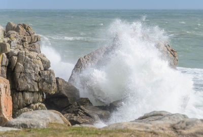 Waves breaking on rocks against sea
