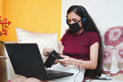 Midsection of woman using phone while sitting on table