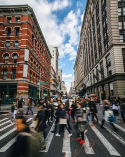 Blurred motion of people walking on zebra crossing in city