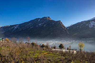 Scenic view of snowcapped mountains against clear blue sky