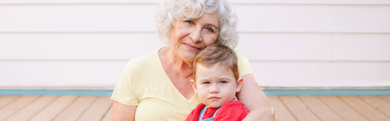 Portrait of grandmother with grandson sitting outdoors