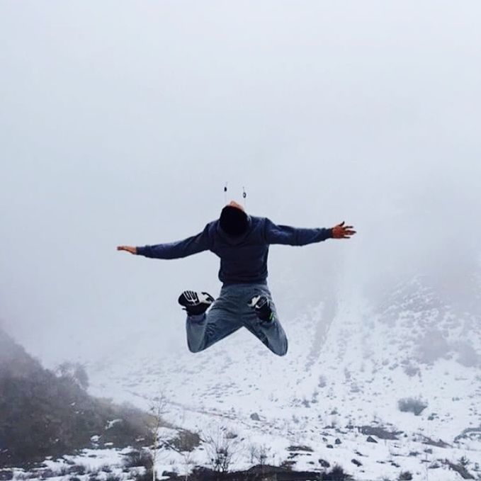 full length, leisure activity, lifestyles, mid-air, winter, snow, arms outstretched, cold temperature, freedom, season, weather, jumping, copy space, clear sky, casual clothing, landscape, extreme sports, enjoyment