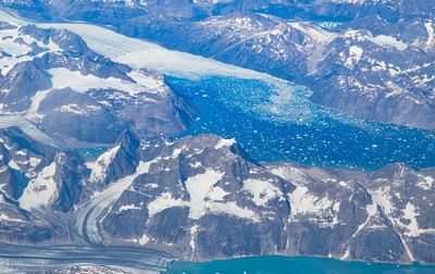 Aerial view of snowcapped mountains by sea