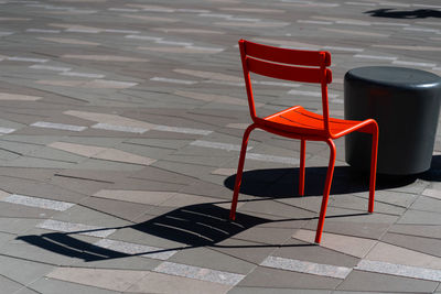 High angle view of empty chair on footpath