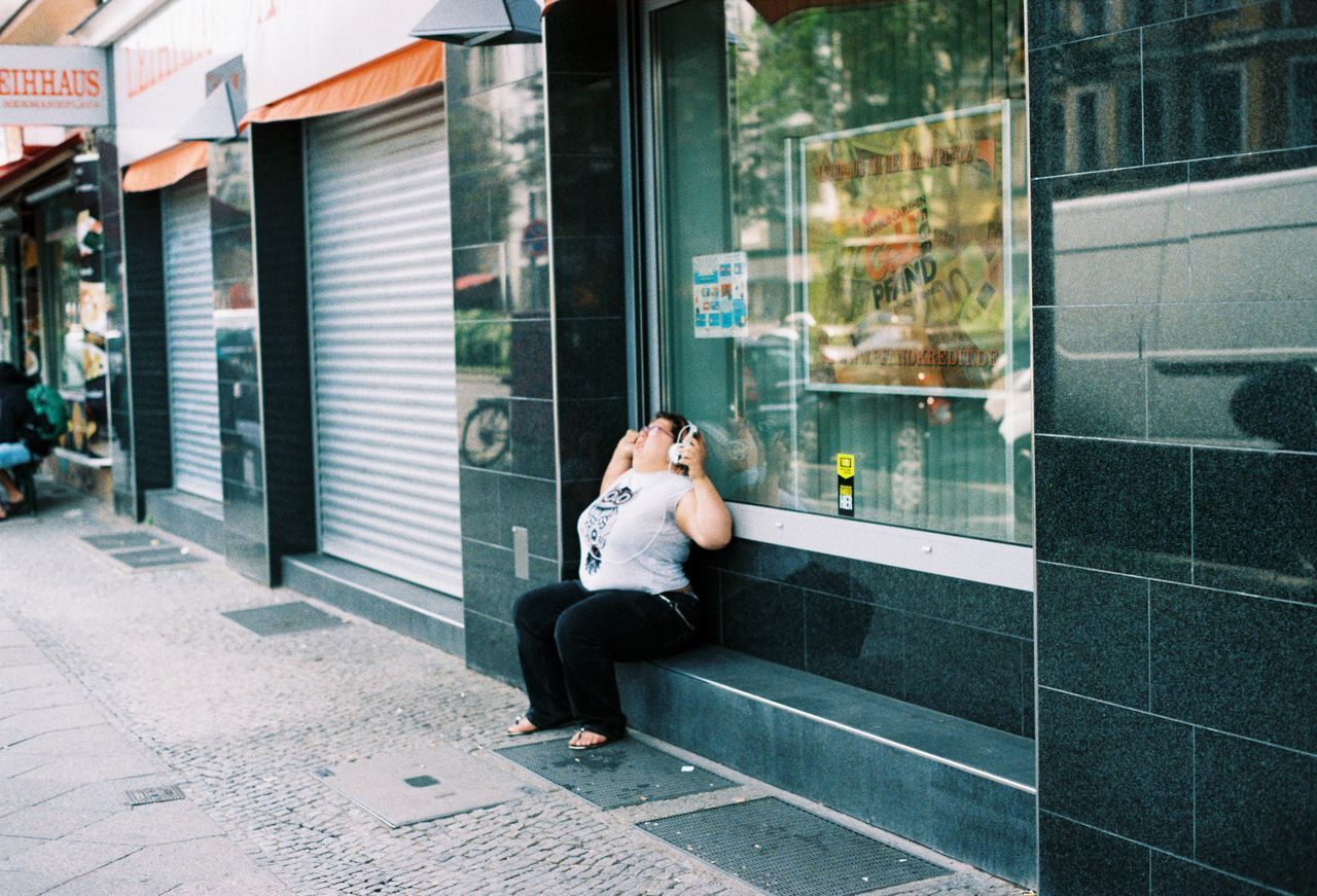 building exterior, one person, architecture, full length, young adult, real people, built structure, adult, sitting, lifestyles, day, glass - material, city, leisure activity, window, women, outdoors, looking, business, contemplation, depression - sadness