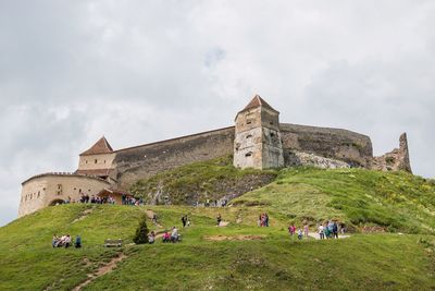 Low angle view of old ruins against cloudy sky