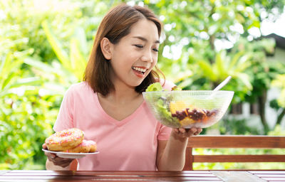 Portrait of a smiling young woman holding ice cream